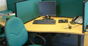 Office cubicle with chair, computer, and phone