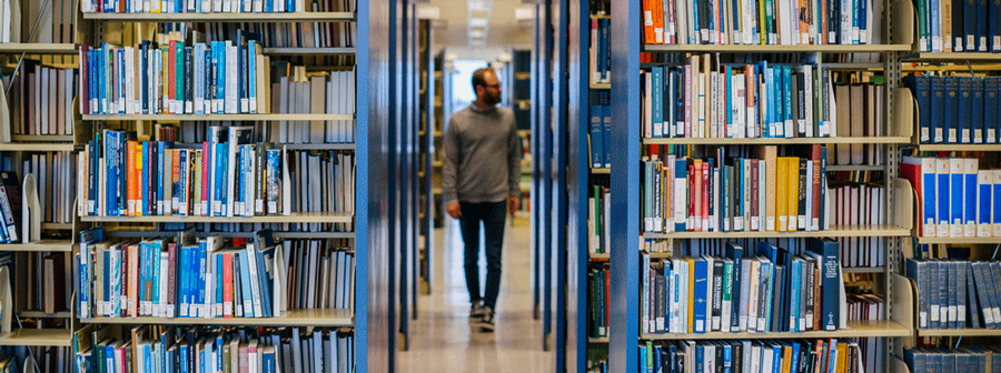 Person walking through library stacks