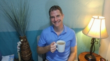 bryan mcnutt seated holding a coffee cup