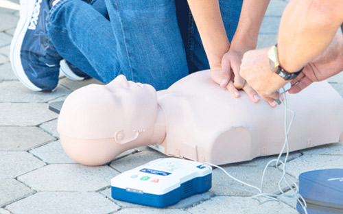 Close up of hands pressing on CPR manikin.