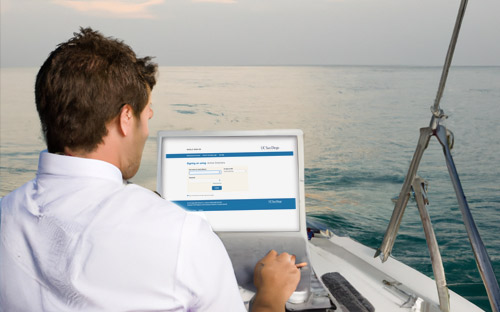 Man on a boat looking at laptop sign in screen
