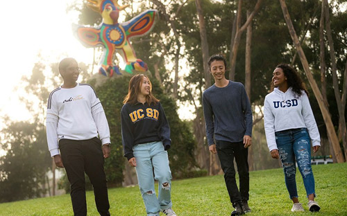 Students walking by the Sun God statue
