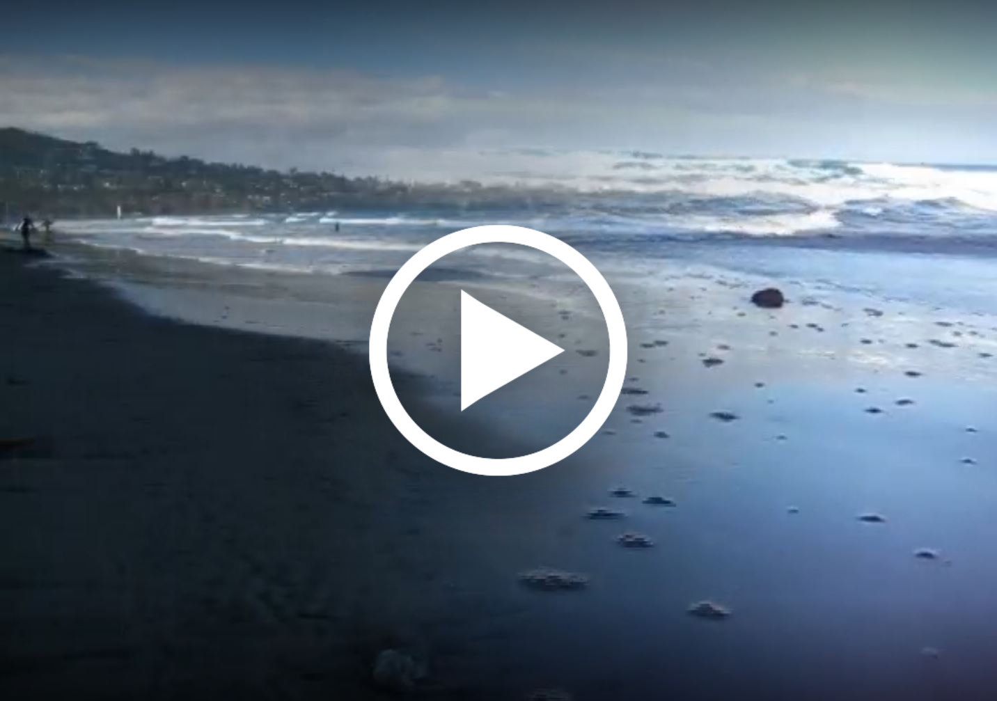 ocean and beach shoreline, with play video icon
