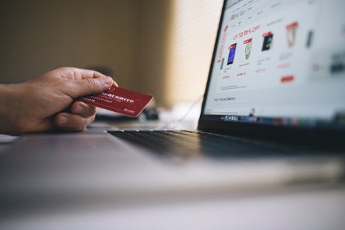 laptop and person holding credit card